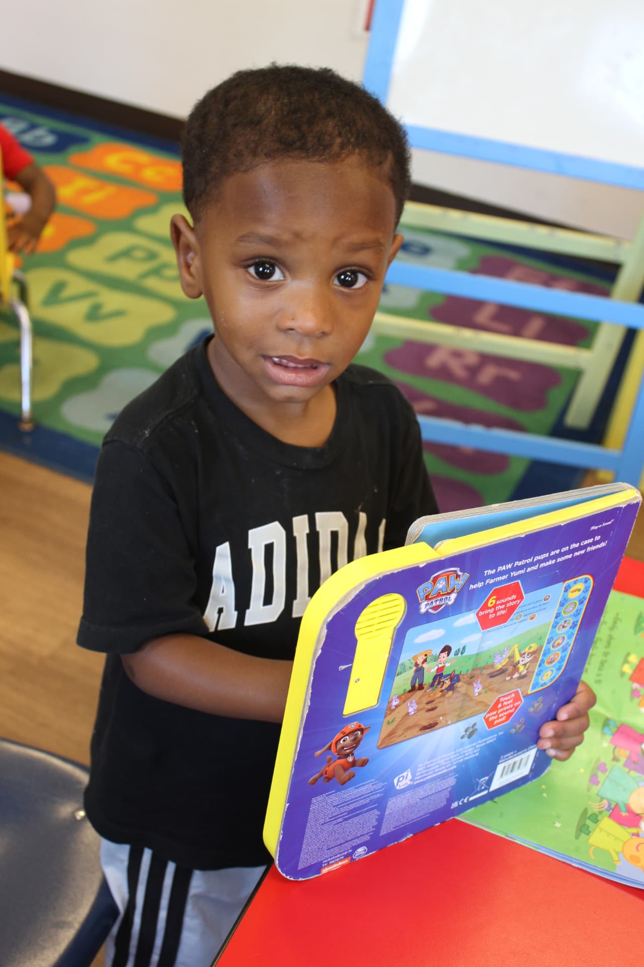 A preschooler proudly sharing a story book